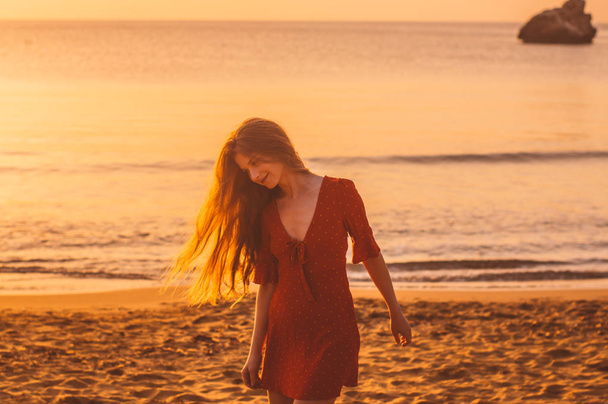 Young blonde girl in red dress walking in the evening - Photo, Image