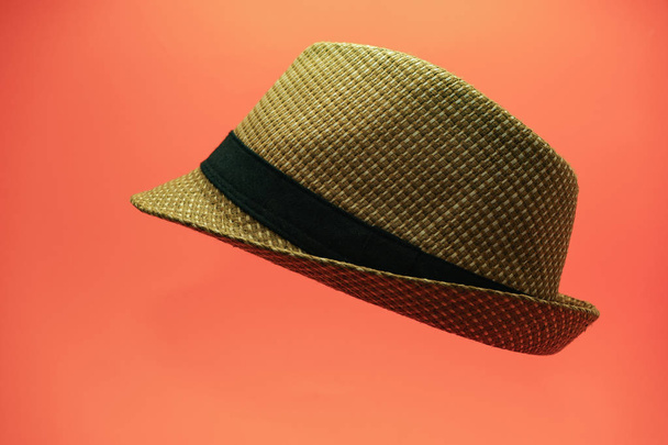 Krásný slaměný klobouk na broskvové pozadí. - Fotografie, Obrázek