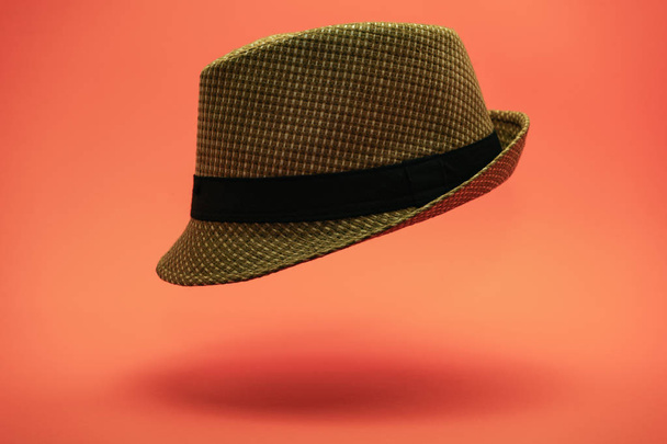 Όμορφο ψάθινο καπέλο σε φόντο ροδάκινο. - Φωτογραφία, εικόνα