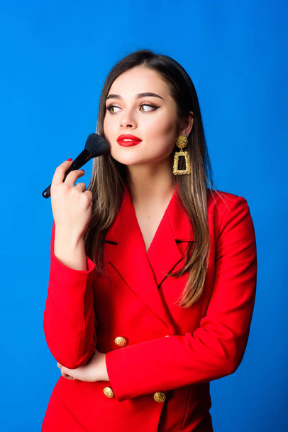 Attractive woman applying makeup brush. Hiding all imperfections. Perfect skin tone. Makeup artist concept. Girl apply powder cheeks. Looking good and feeling confident. Gorgeous lady makeup red lips - Zdjęcie, obraz