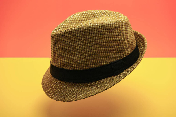 Όμορφο ψάθινο καπέλο σε ροδάκινο και κίτρινο φόντο. - Φωτογραφία, εικόνα
