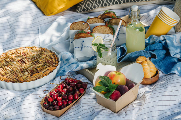 Summertime picnic set with checked tablecloth and healthy food - Foto, imagen