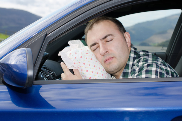 Уставший мужчина спит в машине.
. - Фото, изображение