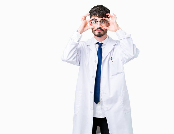 Young professional scientist man wearing white coat over isolated background Trying to open eyes with fingers, sleepy and tired for morning fatigue - Fotoğraf, Görsel