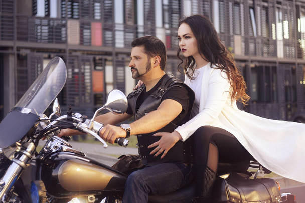 Couple on the background of the office on a motorcycle. The guy  - 写真・画像