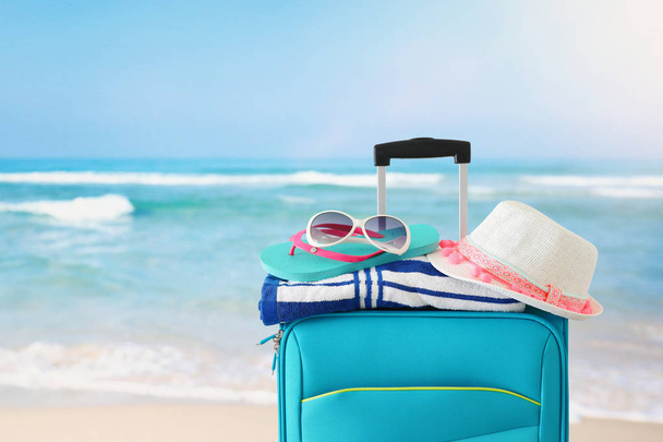 holidays. travel concept. blue suitcase with female hat, flip fl - Fotó, kép