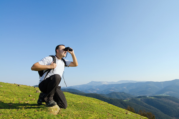 Man with binoculars in the montains. - Valokuva, kuva