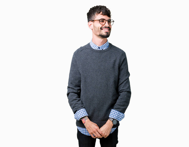 Young handsome smart man wearing glasses over isolated background looking away to side with smile on face, natural expression. Laughing confident. - Photo, Image