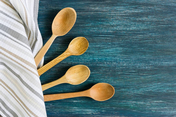 Wooden spoons on a blue vintage wooden background. Flat lay, top view, copy space. - Foto, Bild