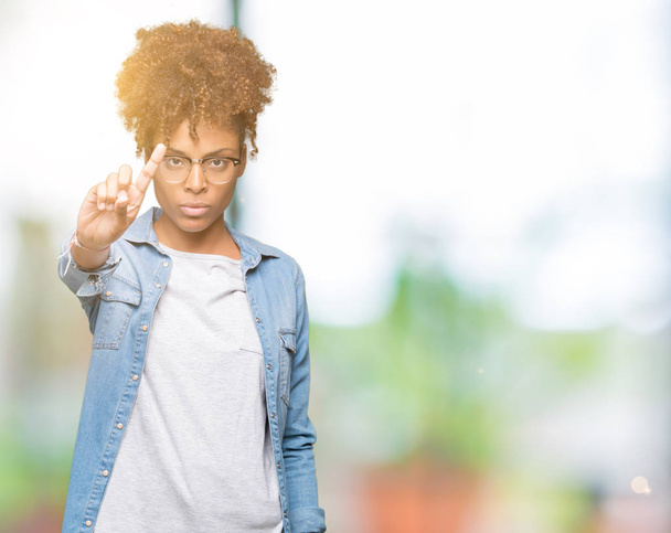 Güzel genç Afro-Amerikan kadın gözlük izole üzerinde arka plan işaret parmağını ve kızgın ifade ile - Fotoğraf, Görsel