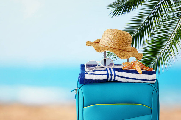 holidays. travel concept. blue suitcase with female hat, starfis - Photo, Image