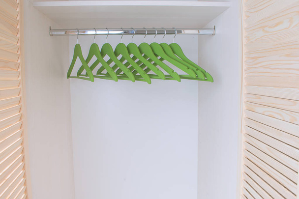 emplty kledingkast plank met groene wodden hanger - Foto, afbeelding