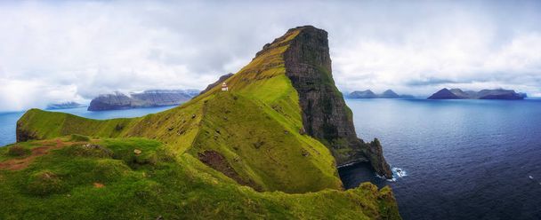 Small lighthouse located near huge cliffs on island of Kalsoy, Faroe Islands - Fotoğraf, Görsel