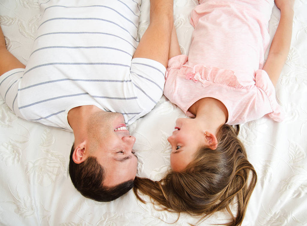 Sorridente padre felice con la sua bambina sdraiata sul
 - Foto, immagini