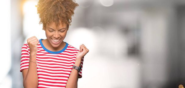 Mooie jonge Afro-Amerikaanse vrouw op geïsoleerde achtergrond erg blij en opgewonden doet winnaar gebaar met armen naar voren gebracht, glimlachend en schreeuwen voor succes. Viering concept. - Foto, afbeelding
