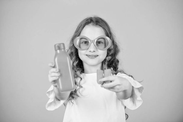 happy girl drink fresh carrot juice. summer vacation. little girl in fashion glasses. Vitamin nutrition. refreshing vitamin juice. Health. Summer vitamin diet. Natural vitamin source. Healthy food - Foto, afbeelding