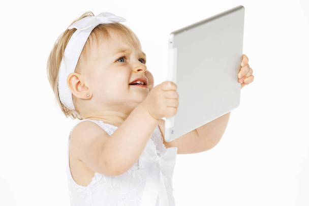 little girl all in white with a tablet - Zdjęcie, obraz