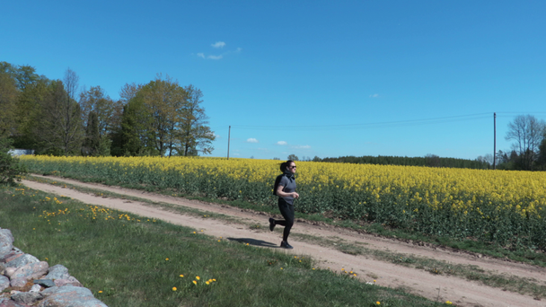 Concept of outdoors activity Female athlete running on open country road - Filmagem, Vídeo