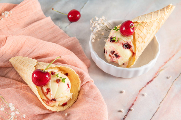 アイスクリームとチェリーフルーツの伝統的なワッフルコーン  - 写真・画像