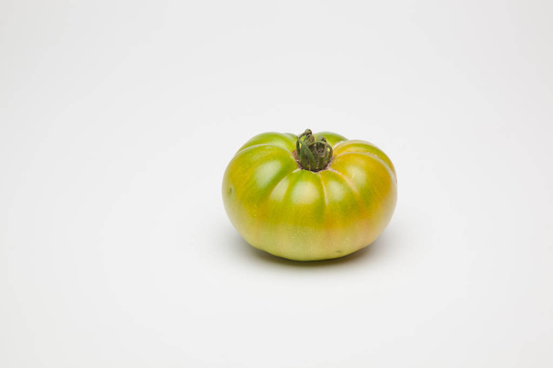 グリーントマトは、最終的な消費者や販売される市場に取られるために庭から持って来た新鮮な。冷蔵庫で少しずつ熟し、食べられるのに最適な色で市場に到着するグリーントマト。生 - 写真・画像