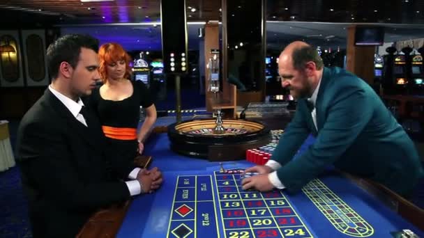 junges Paar spielt Roulette im Casino - Filmmaterial, Video