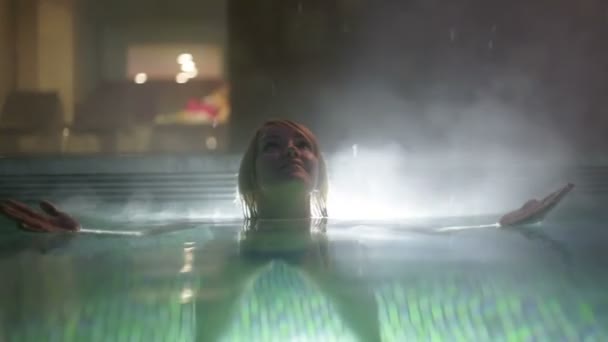 όμορφης κοπέλας που πιάνει Νιφάδες χιονιού την στην εξωτερική πισίνα - Πλάνα, βίντεο