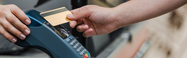 plano panorámico del hombre que paga con tarjeta de crédito cerca del cajero en el supermercado
  - Foto, imagen