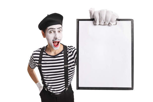 Cheerful mime showing a paper on a clipboard - 写真・画像