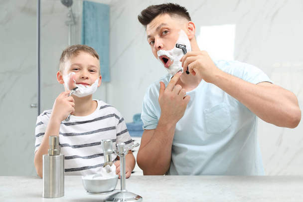 Dad shaving and son imitating him in bathroom - Zdjęcie, obraz