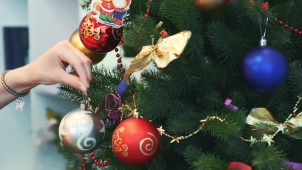 close-up hand van vrouw opknoping speelgoed op kerstboom - Video