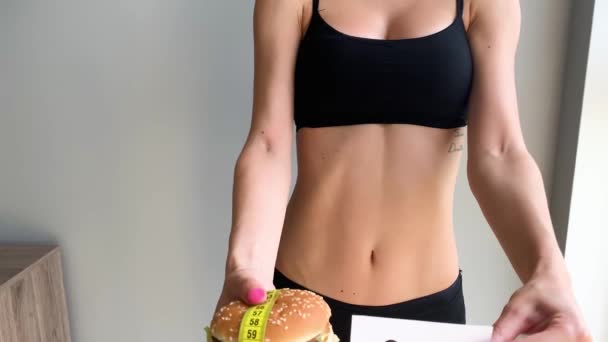 Dieta. Retrato de una mujer quiere comer una hamburguesa, pero una boca pegada, una noción de dieta, comida poco saludable, una voluntad en la nutrición
 - Metraje, vídeo