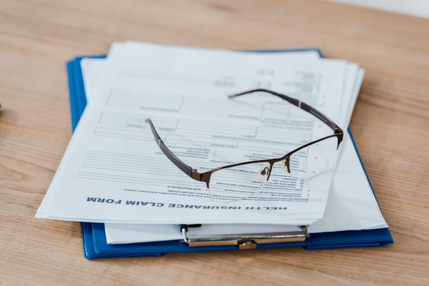 selective focus of glasses on clipboard with documents  - Photo, Image