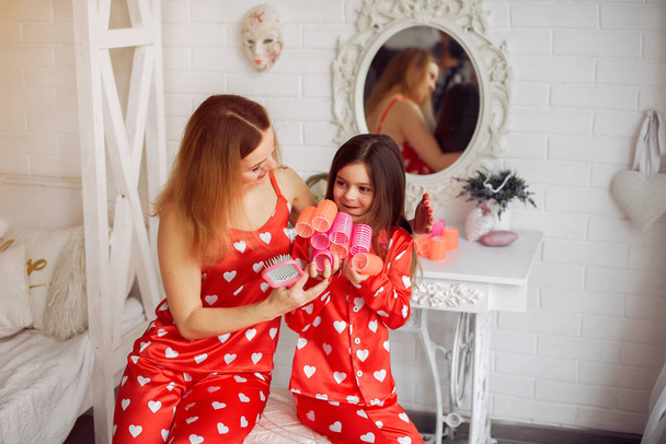 Cute mother and daughter at home in a pajamas - Foto, Imagen