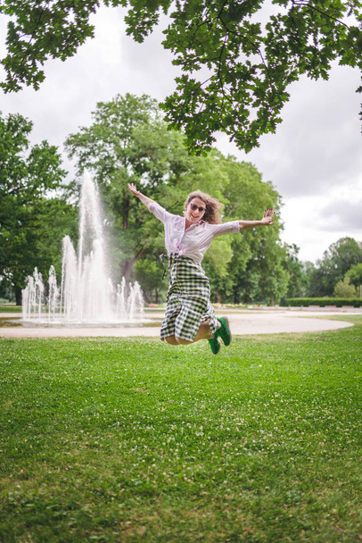 Happiness concept - happy woman having fun in city park during summer - Фото, изображение