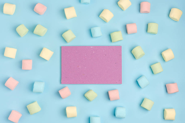 Blue paper background with marshmallow and notepad. Place for your text. Cozy sweet background - Valokuva, kuva