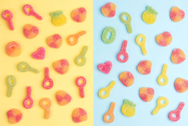 Multicolored gummy candies on yellow and blue backgrounds. Top view. - Foto, Imagen