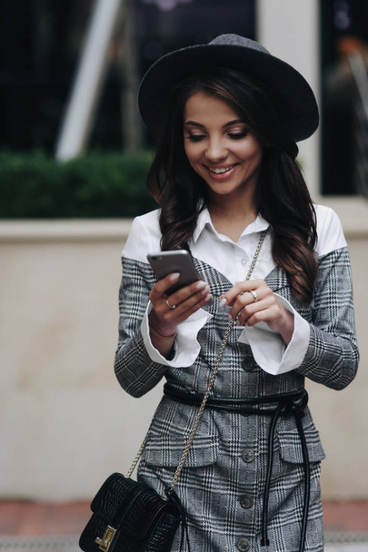 Happy χαμογελαστή κορίτσι διαβάζοντας SMS ειδοποίηση. Τρία τέταρτα μακρά - Φωτογραφία, εικόνα