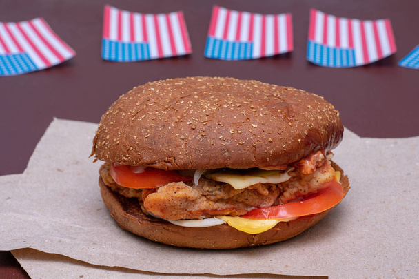 Composition avec drapeau américain et hamburger sur fond sombre. Drapeau américain, drapeau américain
 - Photo, image