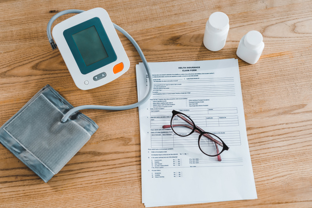 felülnézet a vérnyomásmérő mellett dokumentum és szemüveg  - Fotó, kép