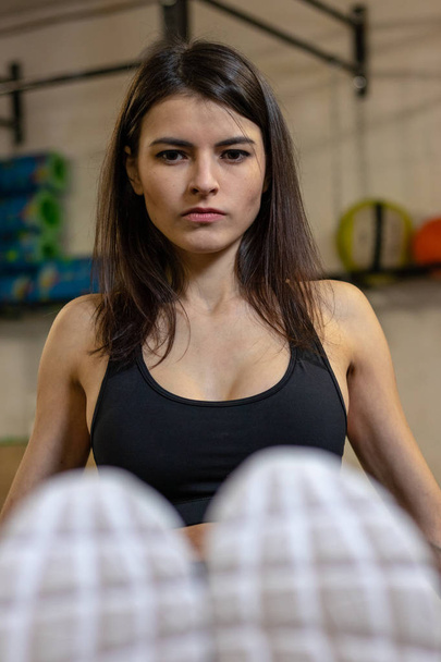 The girl does exercise for the press on the bench in the gym - Photo, image