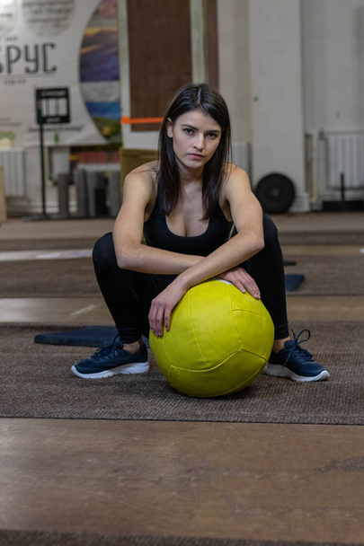 The girl is engaged with a crossfit ball in the gym - Фото, зображення