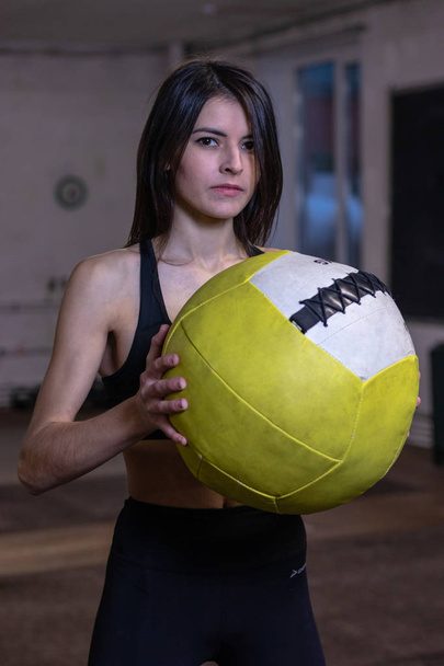 The girl is engaged with a crossfit ball in the gym - Foto, Imagem