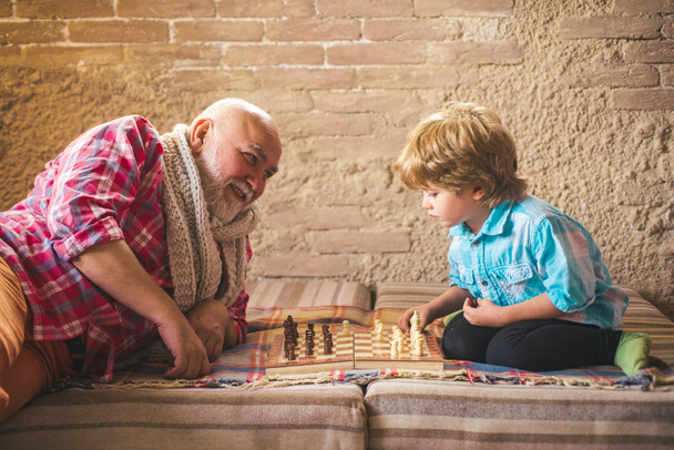 Mature man with little boy playing chess. - Fotoğraf, Görsel