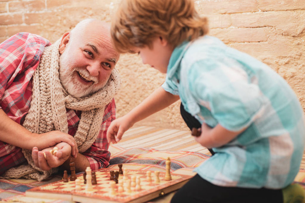 Granddad with grandson on a playing chess. - 写真・画像