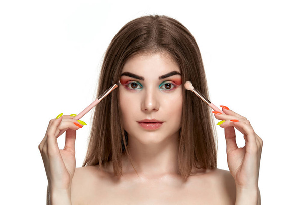 Closeup portrait of beautiful young woman with brushes for make-up - Photo, Image