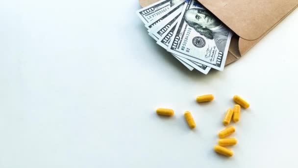 Des médicaments coûteux. Pilules de différentes couleurs et d'argent sur la table blanche
 - Séquence, vidéo