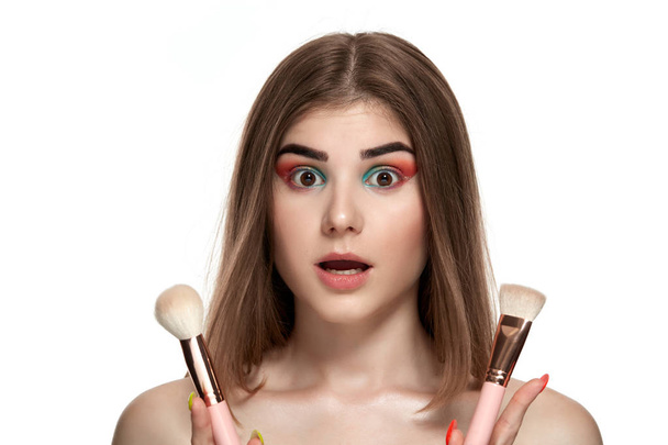 Gros plan portrait de belle jeune femme avec des pinceaux pour le maquillage
 - Photo, image