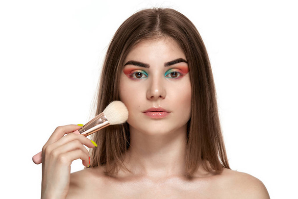 Портрет красивой молодой женщины с кисточками для макияжа
 - Фото, изображение
