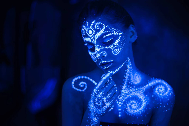 Body art on the body and hand of a girl glowing in the ultraviolet light. - Fotografie, Obrázek