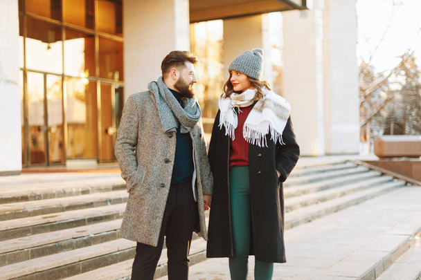 Photo of a dating couple,  a winter walking  day, holding hands and looking to each other - Photo, Image